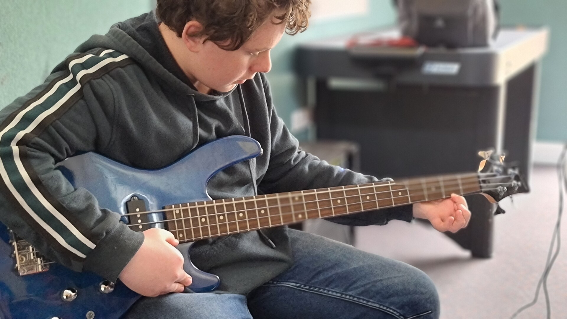 student playing guitar in music class at Galilee School